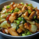 Poulet chinois sauté au chou dans une grande poêle avec légumes colorés