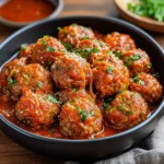 Boulettes italiennes dorées nappées de sauce tomate maison dans une poêle rustique