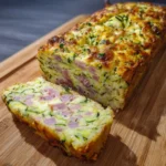cake salé froid courgette fromage coupé en tranches sur une assiette en bois