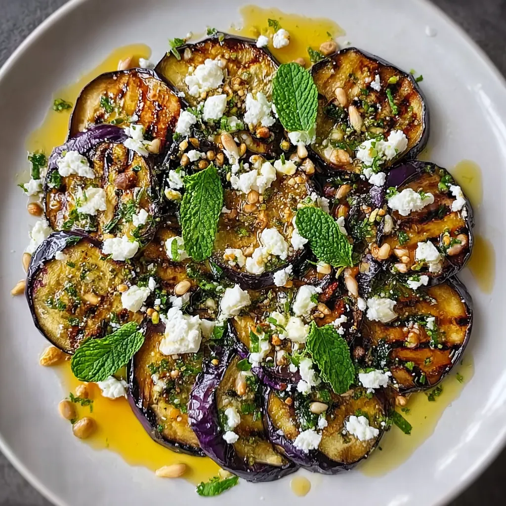 Carpaccio d’aubergines grillées dressé avec feta, menthe fraîche et zeste de citron sur assiette blanche