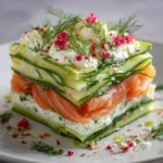 Lasagnes d'été au saumon et concombre dans un plat en verre, servies froides avec des herbes fraîches