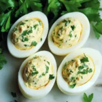 Œufs Durs à la Dijonnaise farcis à la moutarde de Dijon et échalote sur assiette blanche