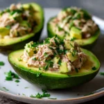 Avocats farcis au thon servis sur une assiette avec salade verte