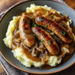 Bangers and Mash avec Sauce à la Bière et Oignons servi dans une assiette