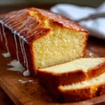 Cake au yaourt ultra moelleux doré et tranché sur une planche en bois
