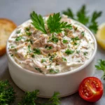 Bol de crème au thon apéritive garni de ciboulette et servi avec des crackers croustillants