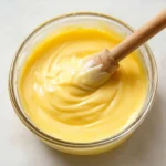Crème de citron maison onctueuse servie dans un petit bol en verre