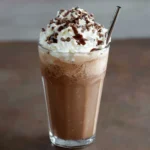 Frappuccino au chocolat maison dans un grand verre avec chantilly et copeaux de chocolat