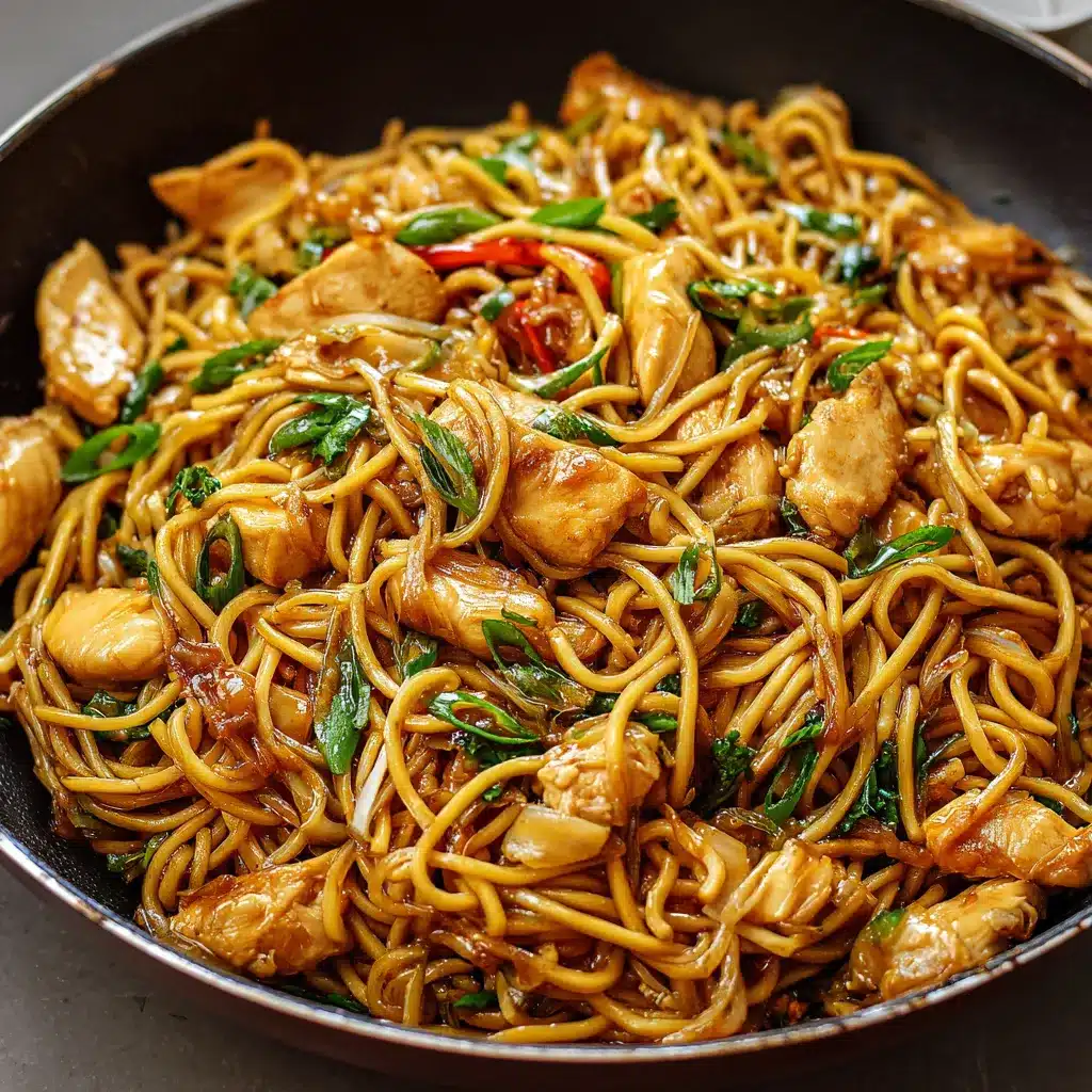 Assiette de Lo Mein au Poulet et à l’Ail garnie de légumes colorés et de nouilles brillantes