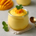 Mousse à la mangue servida en verrines con decoración de mango fresco y crema batida