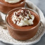 Mousse au chocolat onctueuse servie en verrine, décorée de chantilly et copeaux de chocolat.