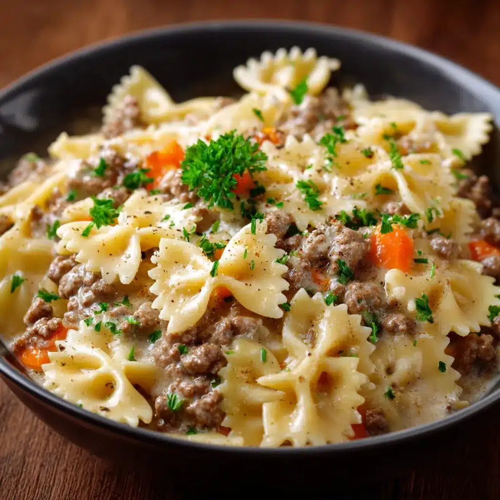 Assiette de farfalle nappée de sauce crémeuse au bœuf haché, parsemée de persil frais