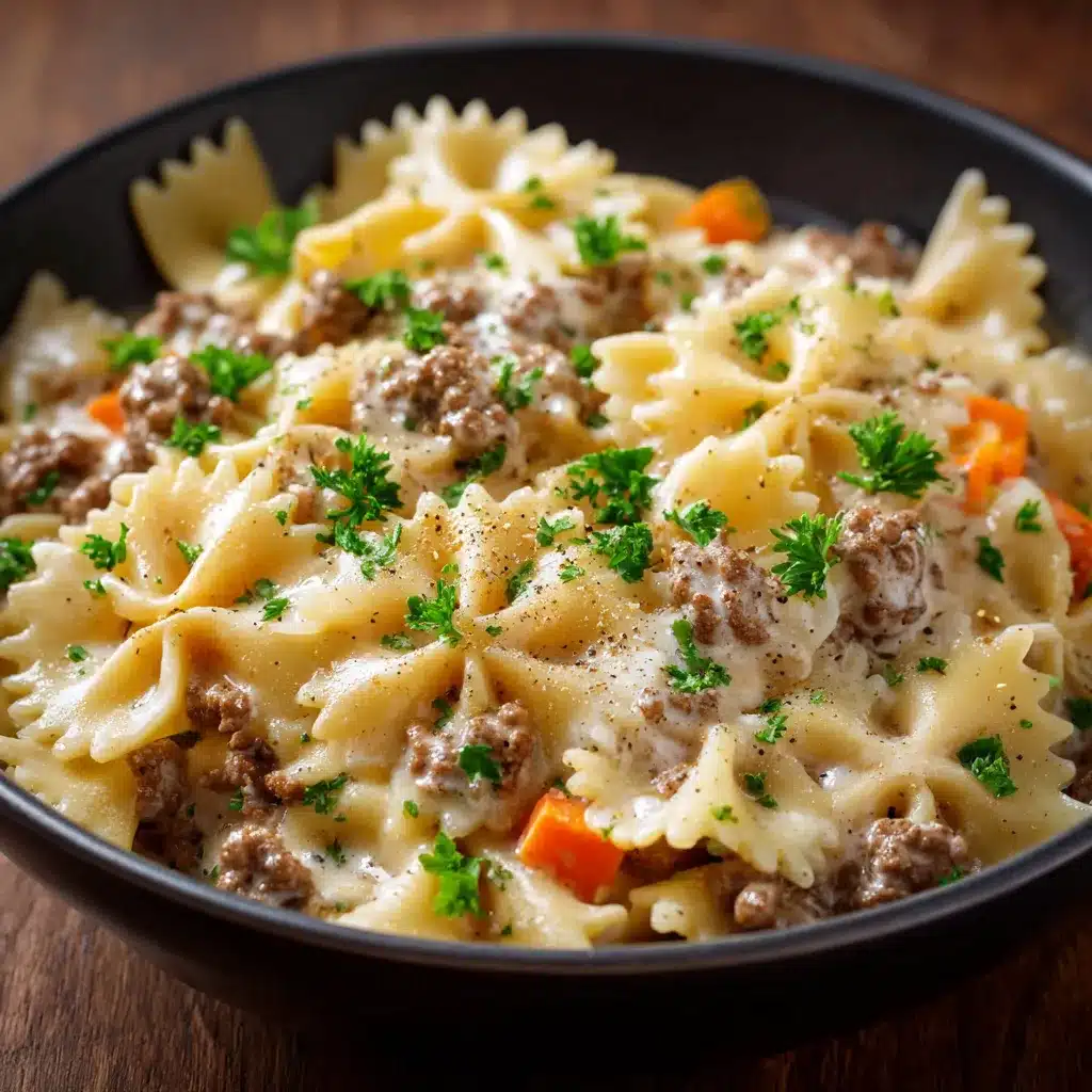 Assiette de farfalle nappée de sauce crémeuse au bœuf haché, parsemée de persil frais
