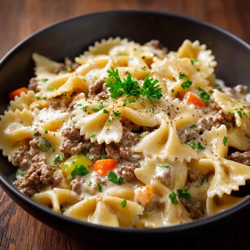 Assiette de farfalle nappée de sauce crémeuse au bœuf haché, parsemée de persil frais