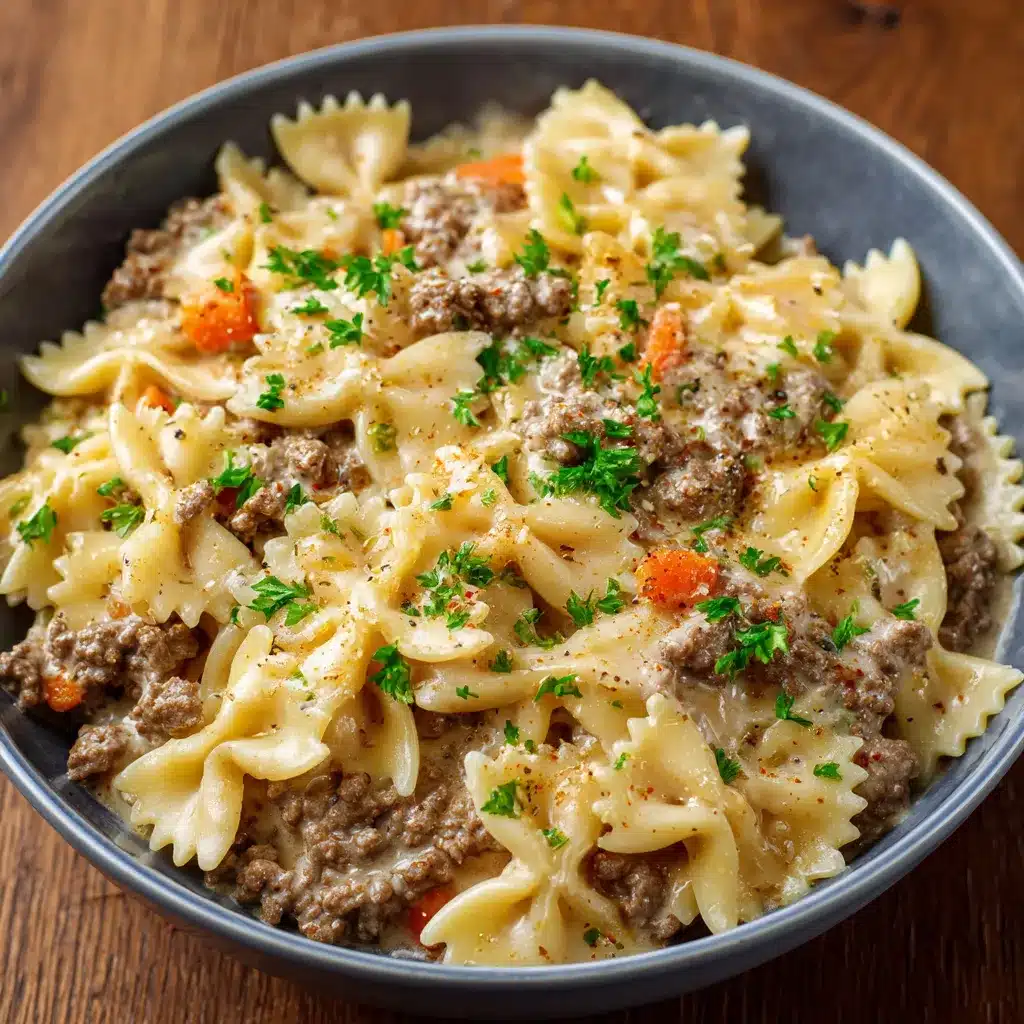 Assiette de farfalle nappée de sauce crémeuse au bœuf haché, parsemée de persil frais