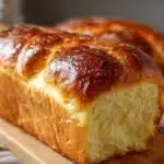Brioche maison ultra moelleuse dorée sortie du four, posée sur une grille
